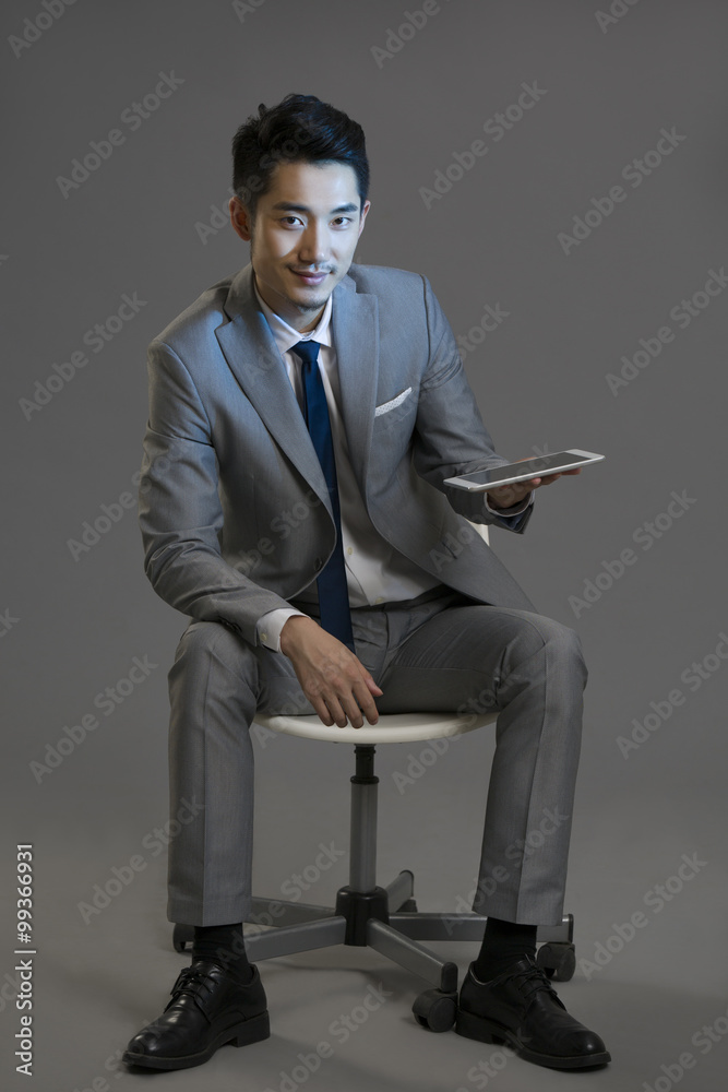 Happy young businessman using digital tablet