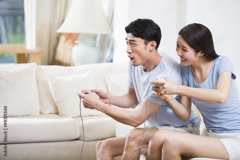 年轻情侣一起玩电子游戏