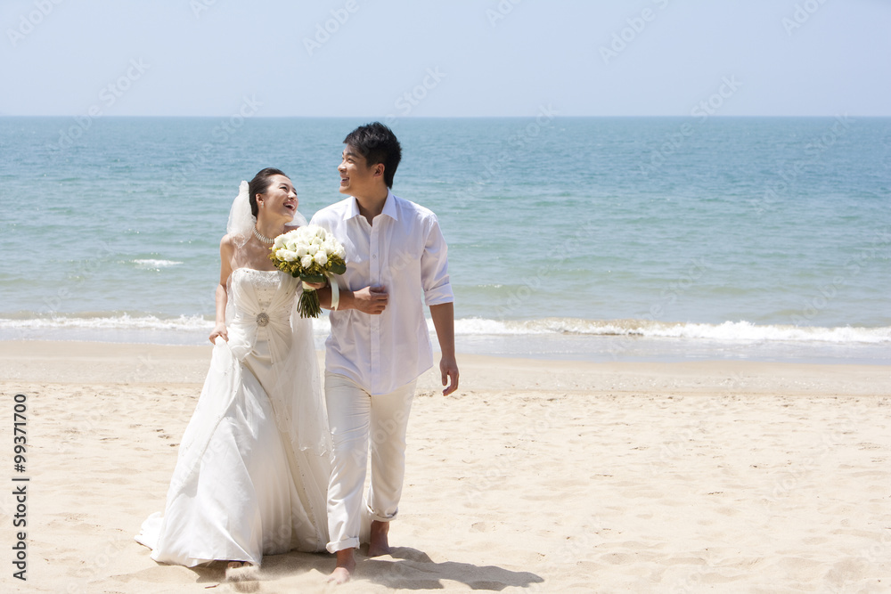 新婚夫妇在海滩上散步