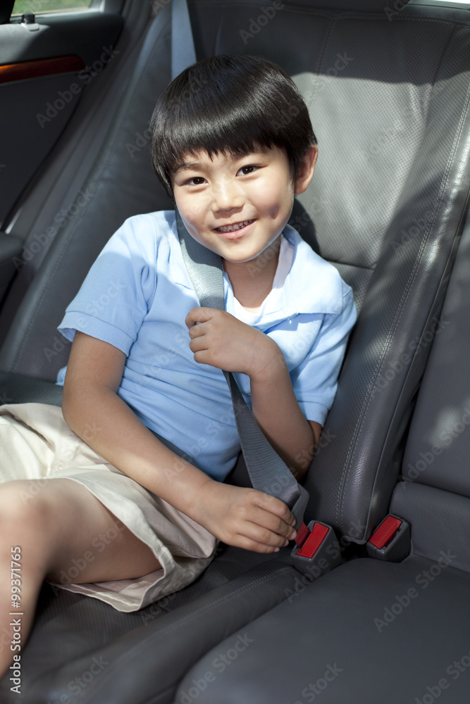 坐在汽车后座的可爱小男孩