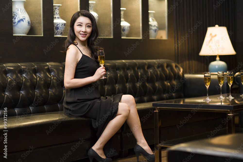 Young woman drinking alcohol in luxury club