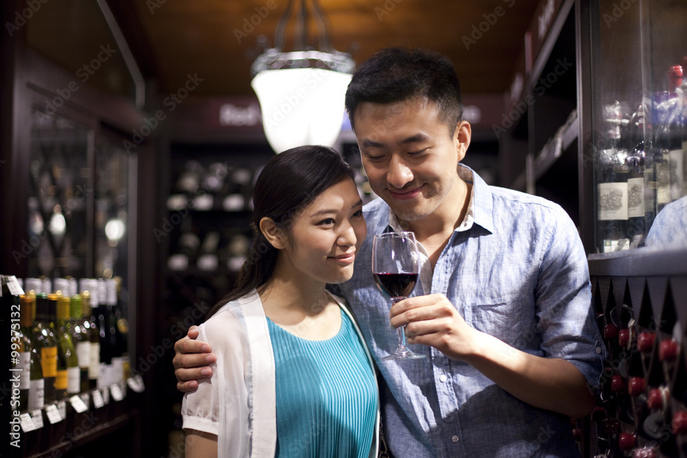 Young couple tasting wine in cellar