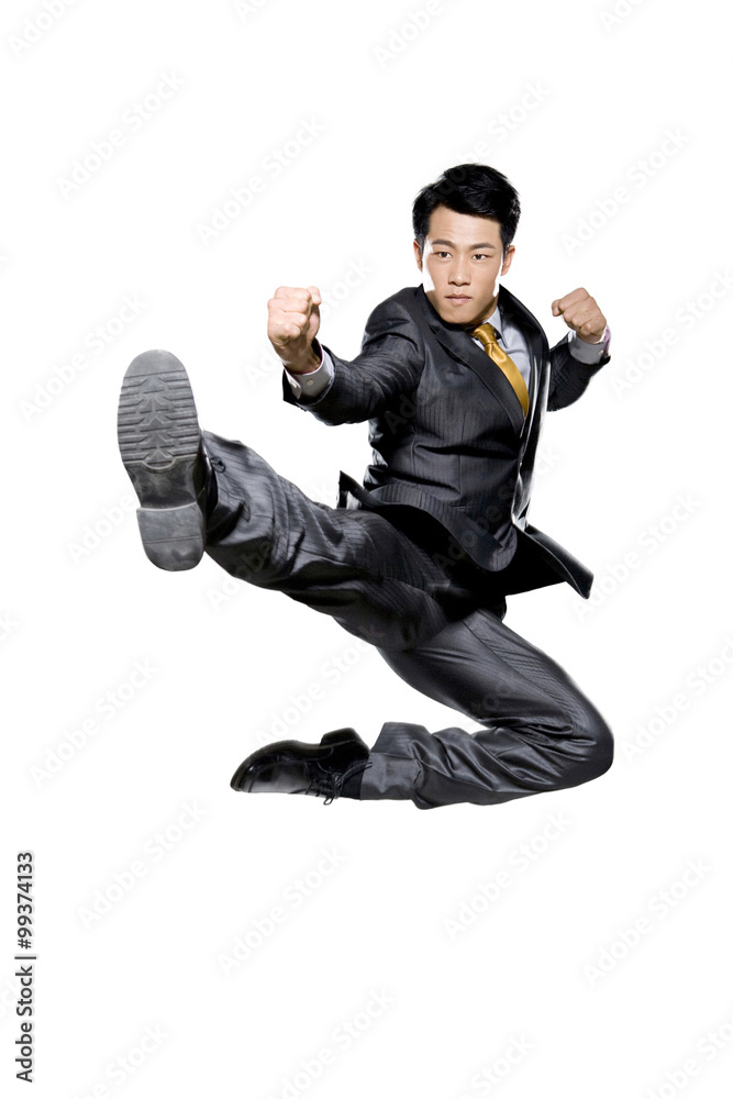 Businessman in martial arts position mid-air