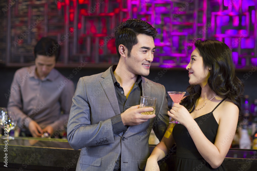 Young man and woman flirting at bar