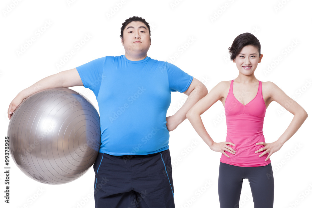快乐的胖男人和年轻的女人用健身球