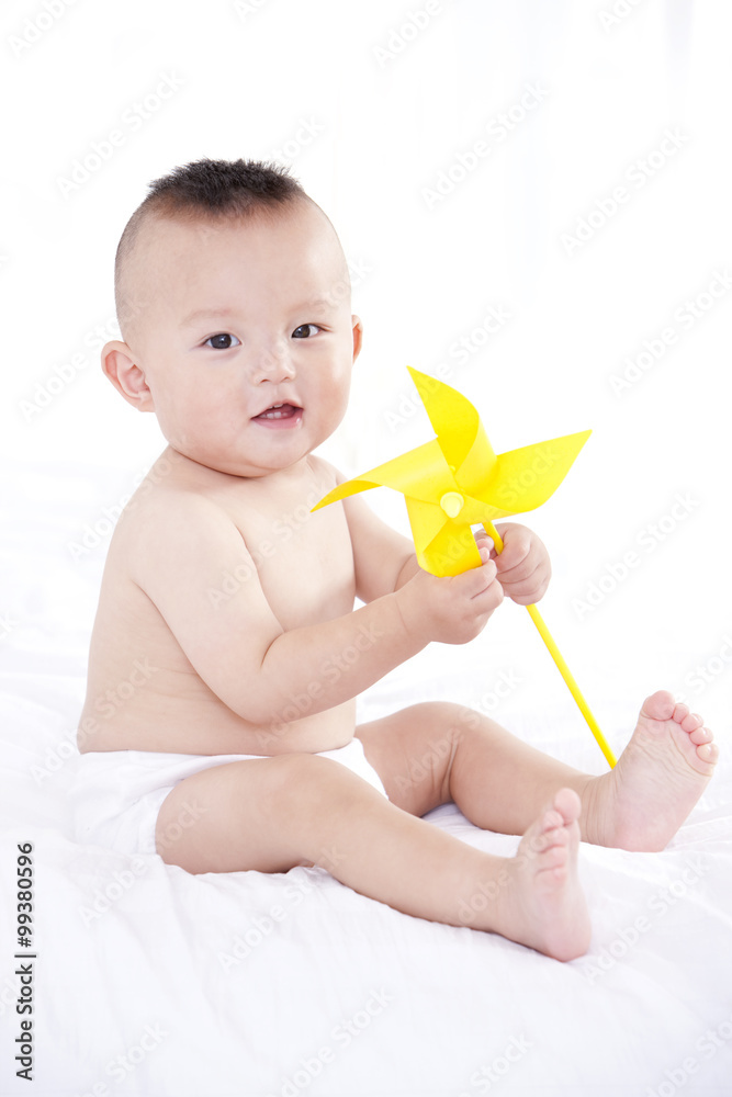 带着玩具风车的无辜婴儿画像