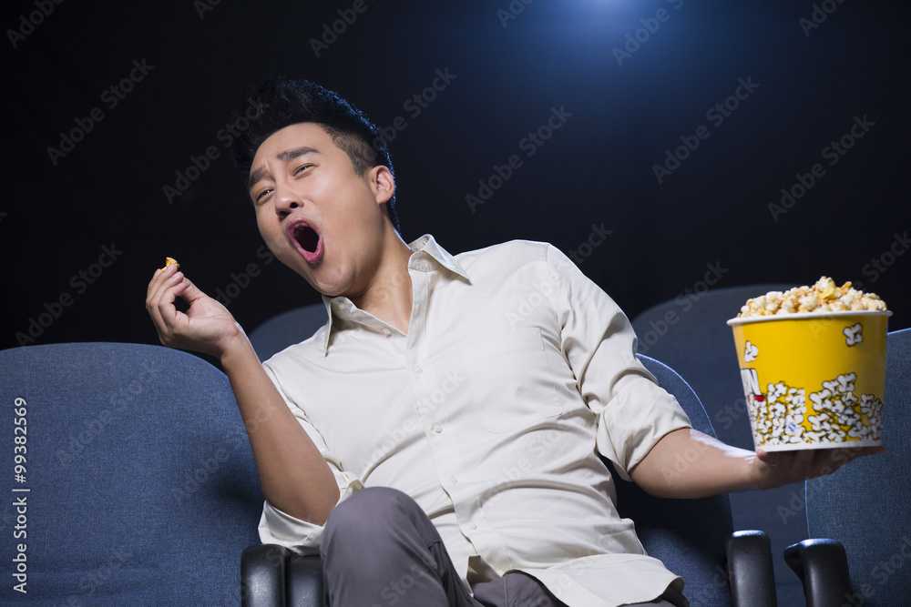 Young man laughing while watching movie