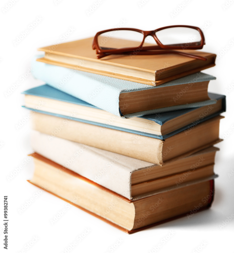 白色背景上的一堆书和眼镜