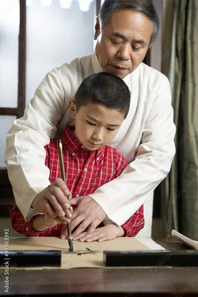 男人教他的孙子书法艺术