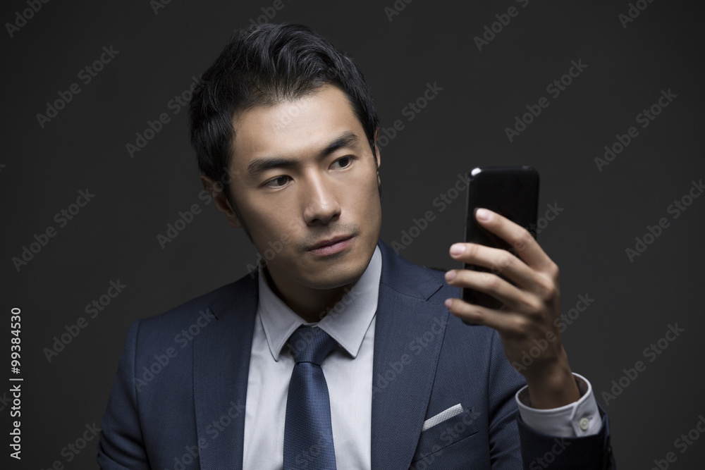Confident businessman using smart phone