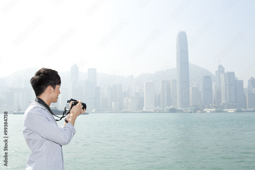 香港维多利亚港用单反相机拍摄年轻人