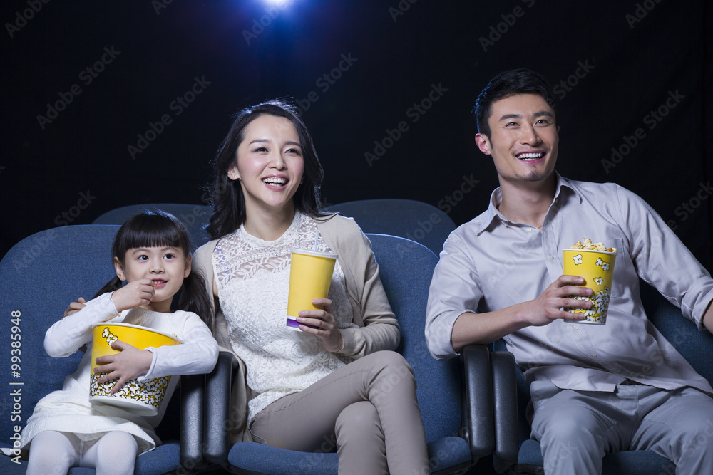 年轻的一家人在电影院看电影