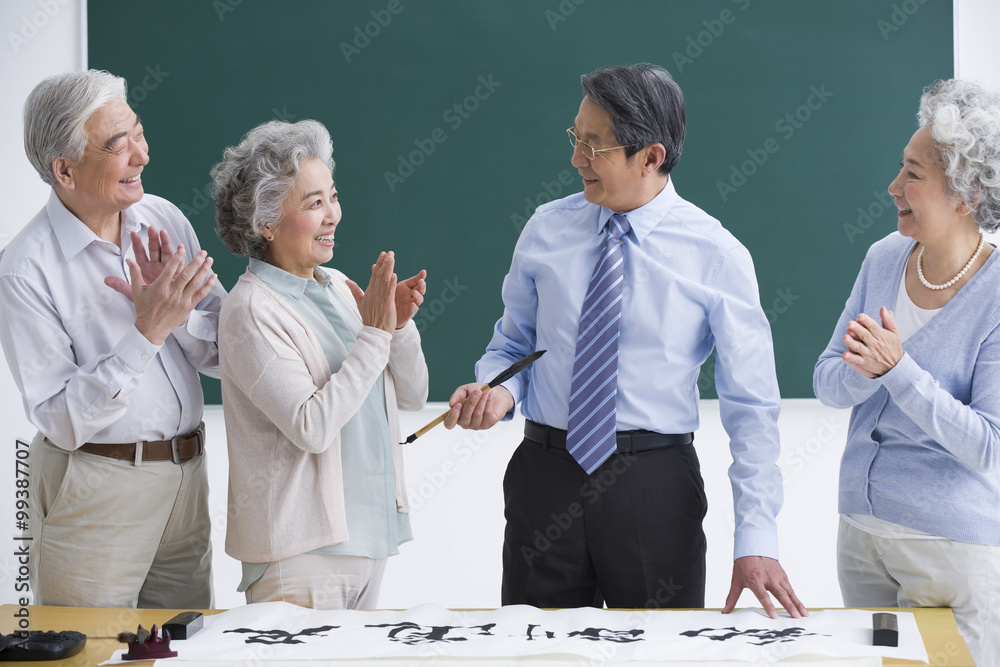 Senior adults having calligraphy class at school