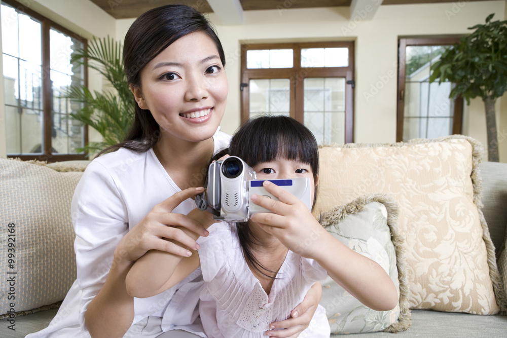 母亲和女儿使用数码摄像机