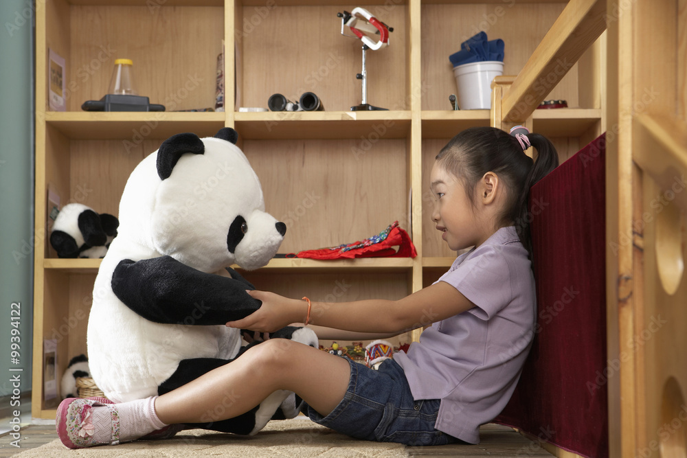 年轻女孩与填充玩具熊猫交谈