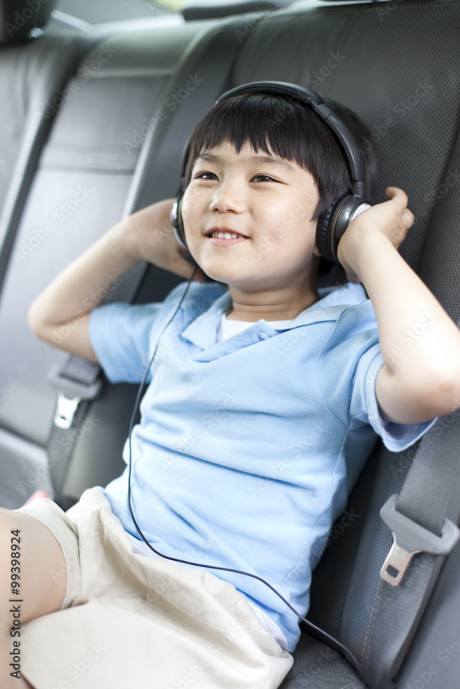 小男孩坐在车里听音乐