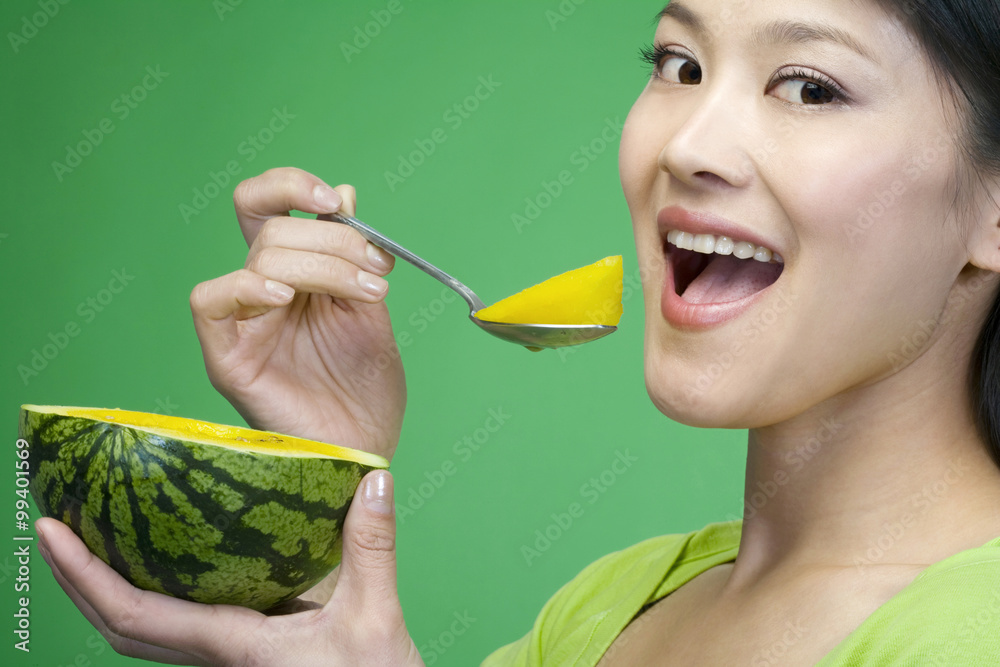 Woman in green eating a melon