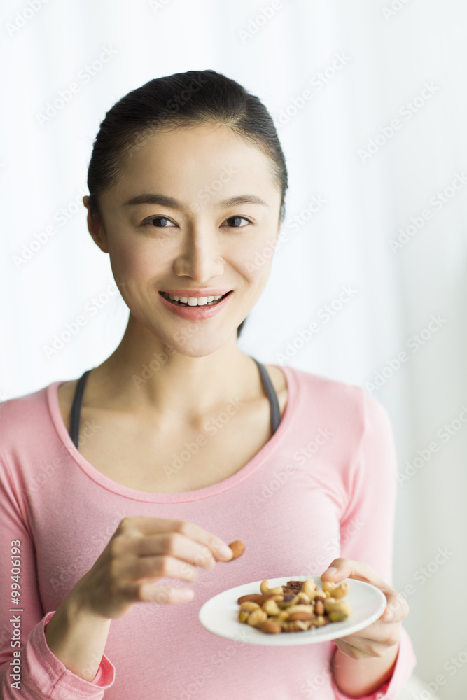 快乐的年轻女人吃坚果