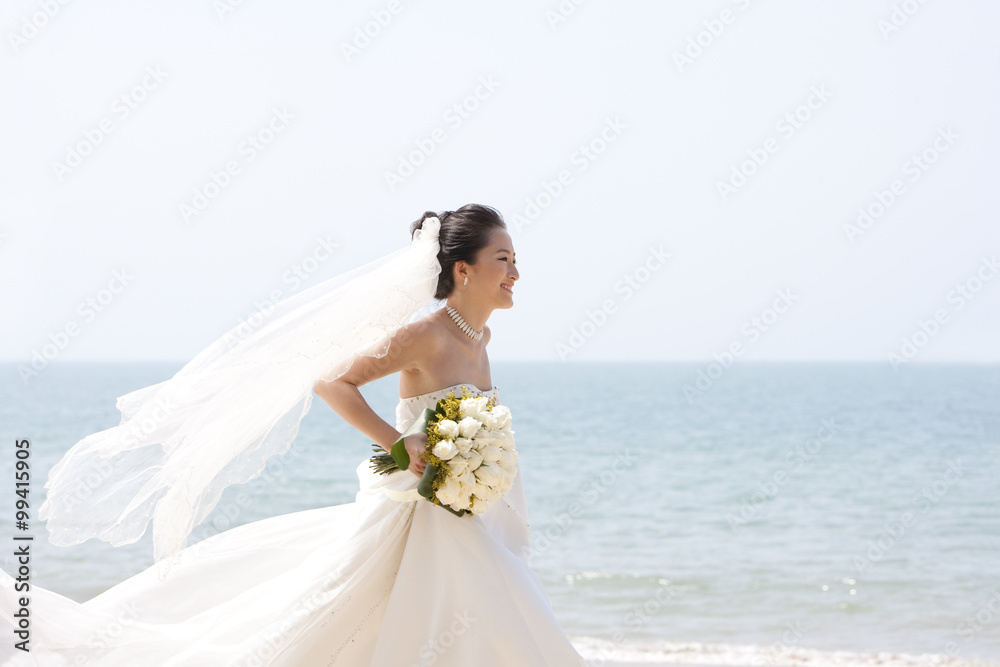 快乐的新娘在海滩上奔跑