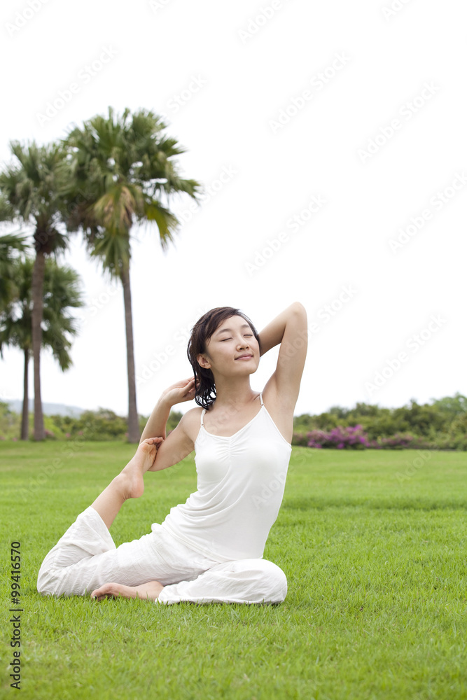 一个女人在草地上练习瑜伽