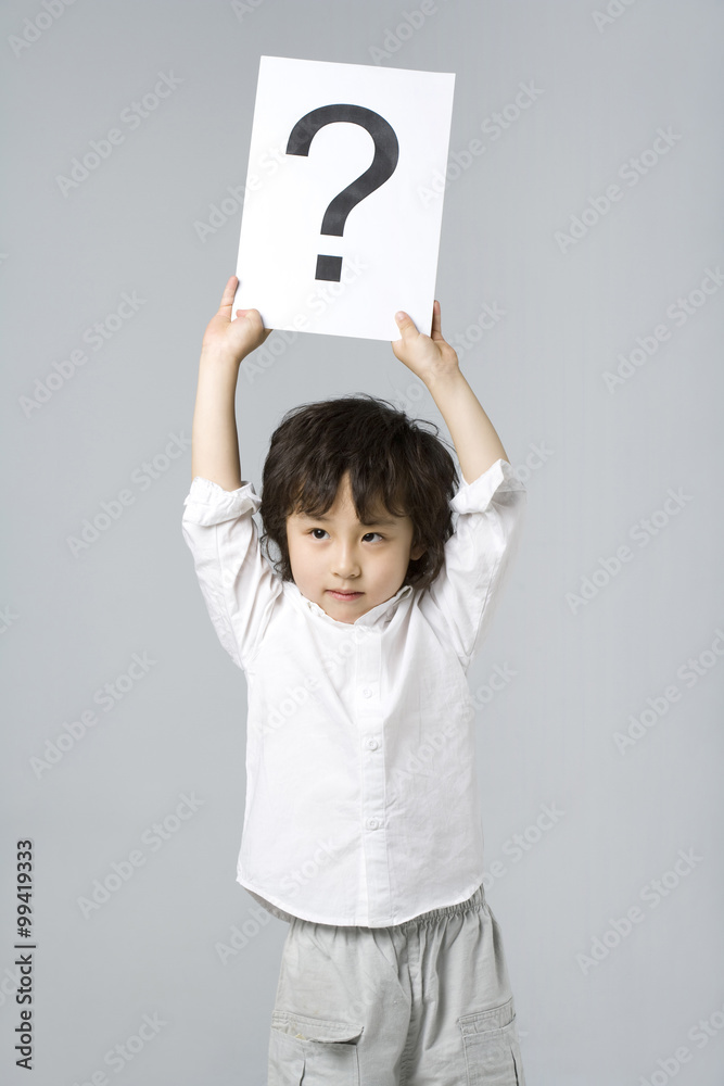 Little boy holding a sign with a question mark