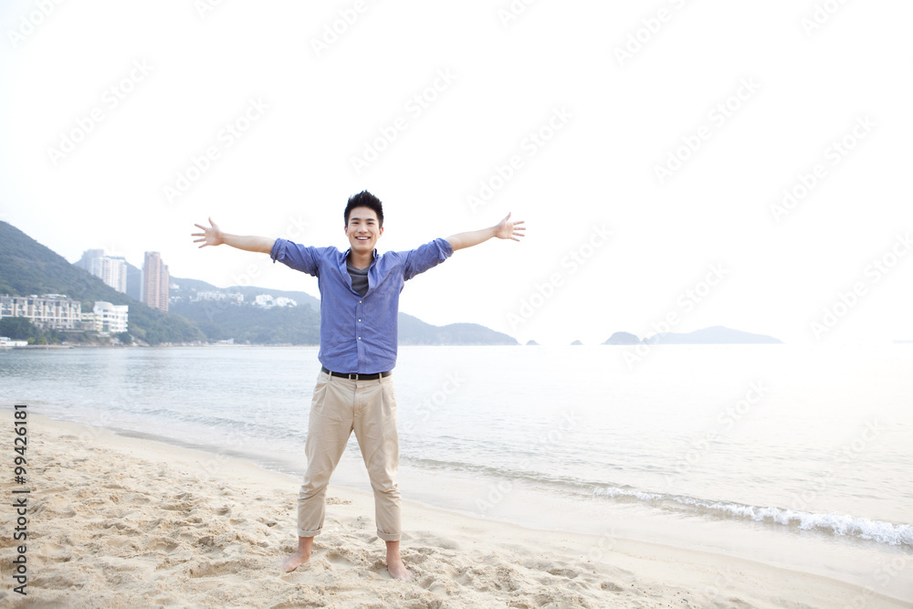 香港浅水湾海滩上，欢快的年轻人伸出双臂