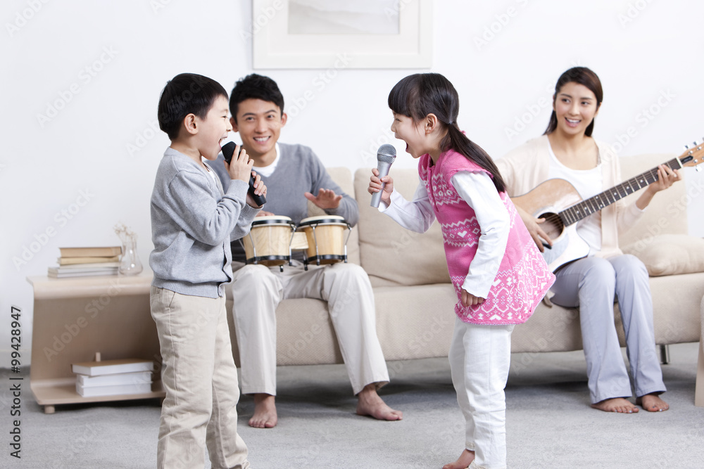 兴奋的年轻家庭在家演奏乐器和唱歌