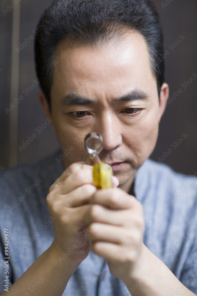 Male jeweler examining a jewelry