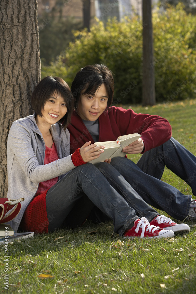 年轻情侣在公园读书