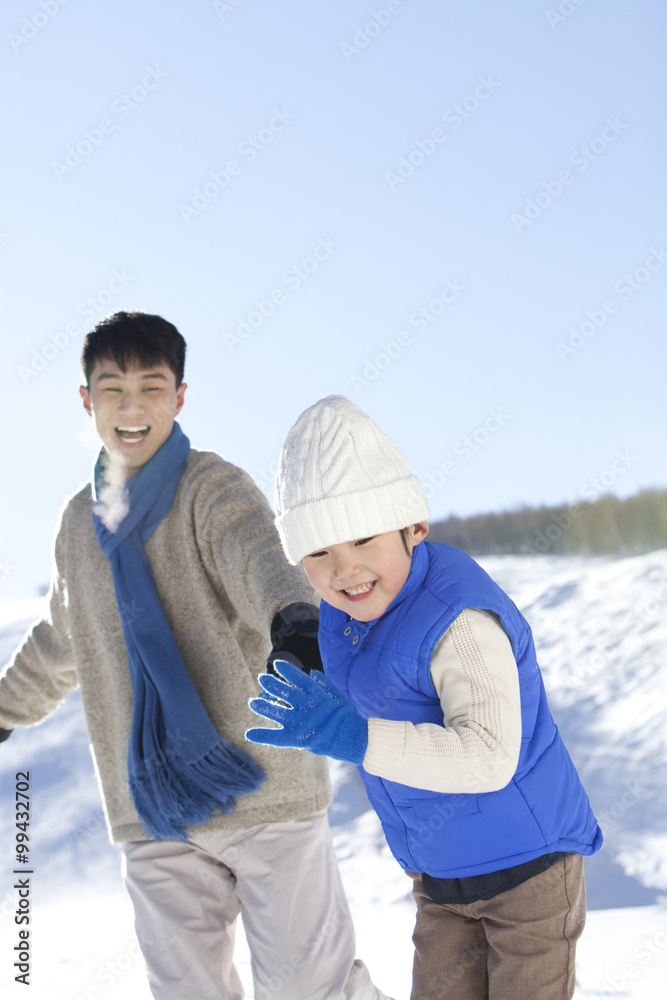 父亲在雪地里和儿子玩耍