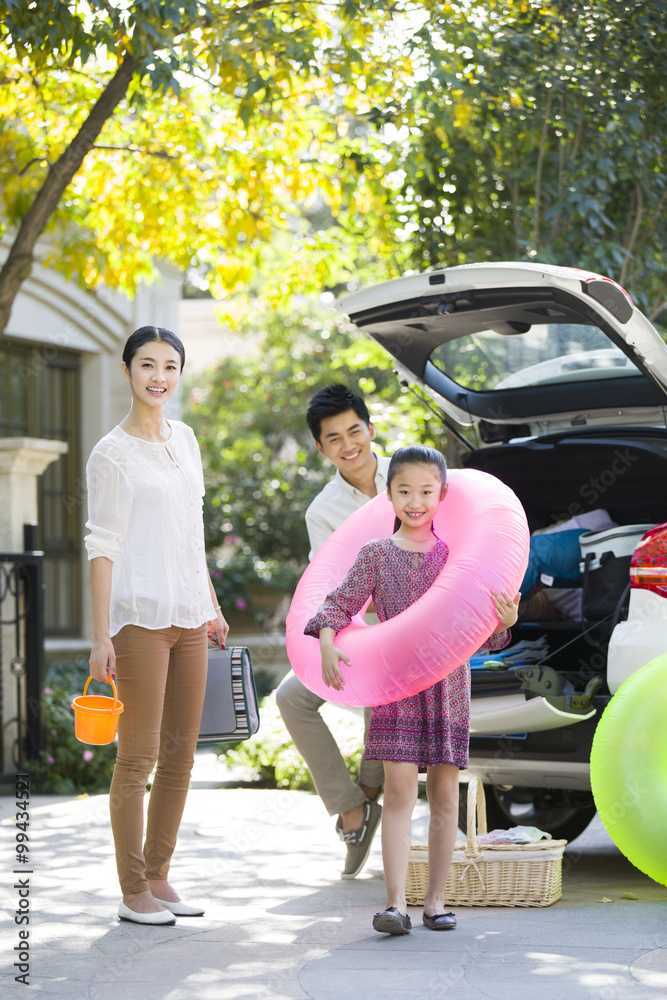 Young family putting water sports equipment into the car