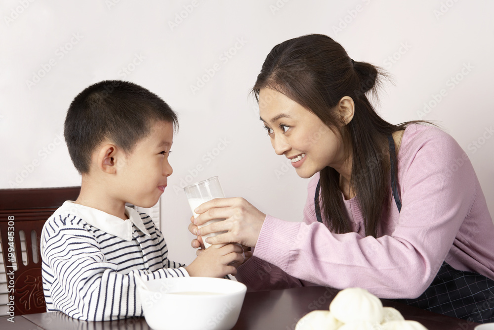 Mother Giving Son A Glass Of Milk