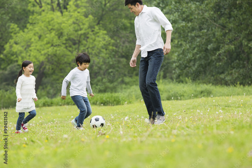 Happy father and children playing football together
