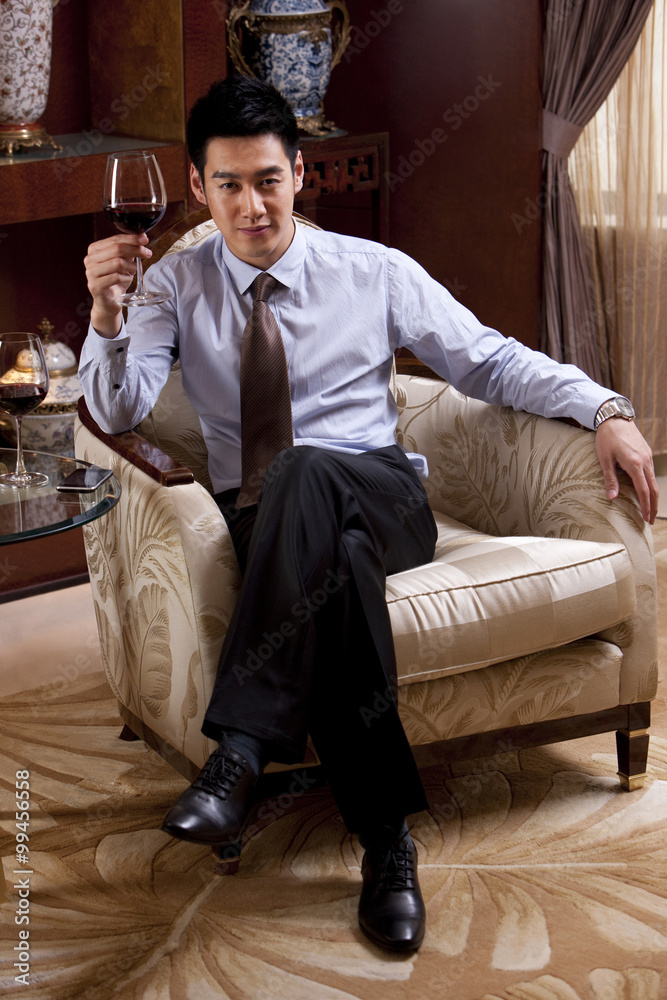 Young businessman enjoying wine in hotel