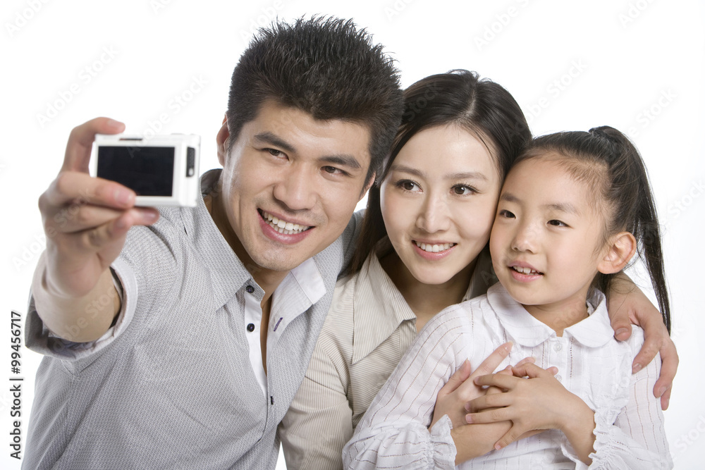 Family of three taking photo by digital camera