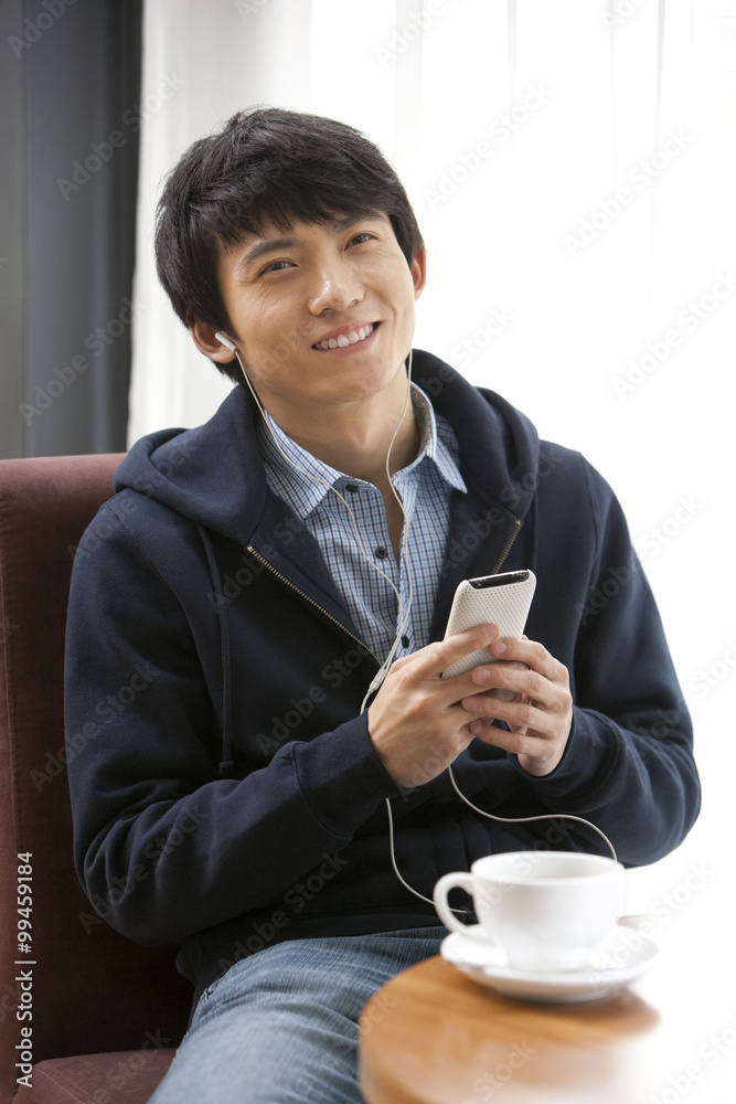 一个年轻人在咖啡馆听mp3