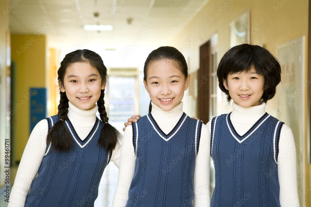三名女生并排站在学校微笑