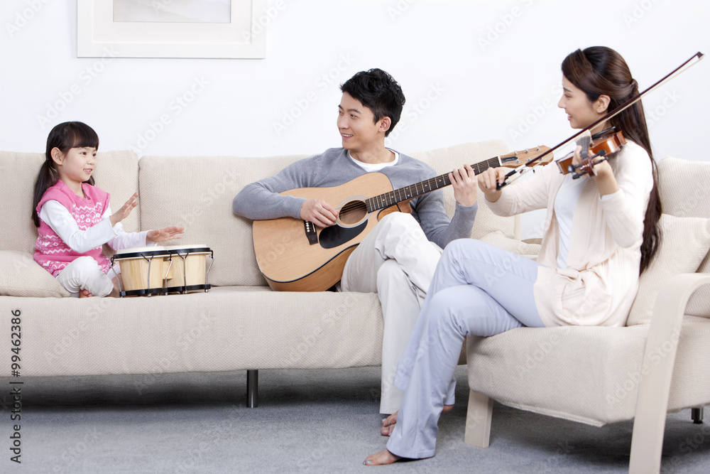 快乐的年轻家庭在家演奏乐器