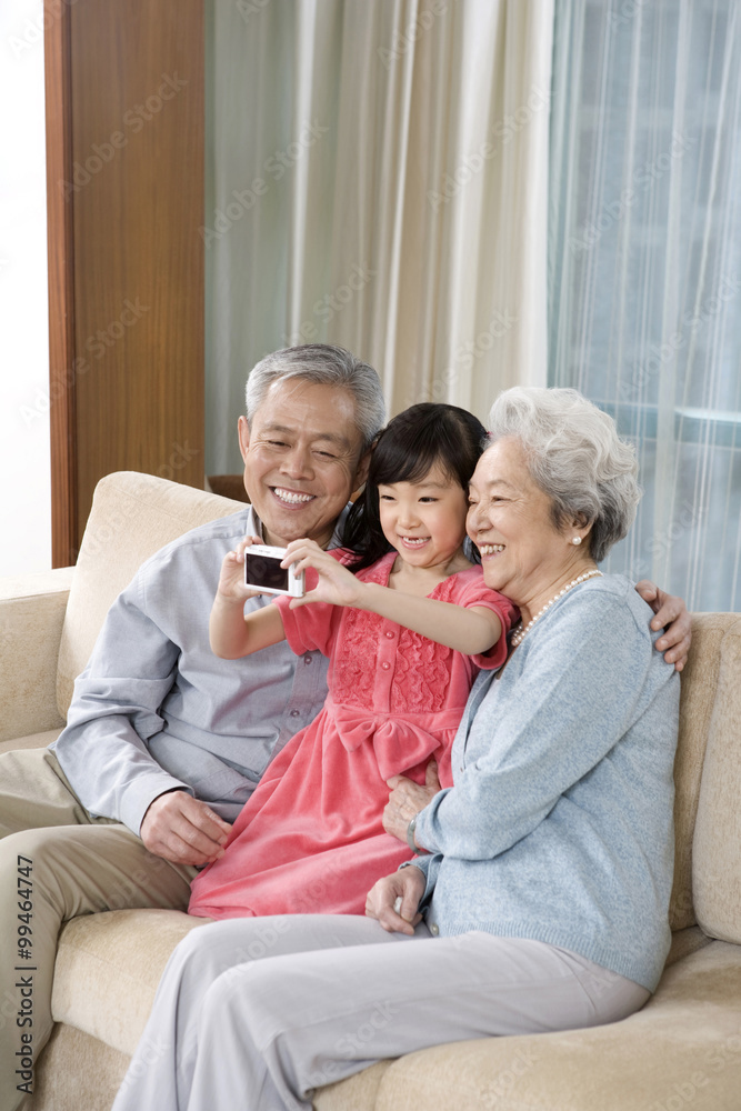 Elderly couple with granddaughter on couch