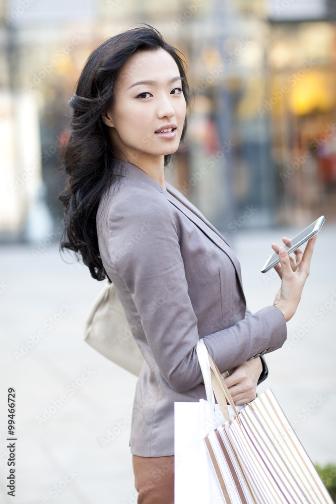 带着购物袋和智能手机的快乐年轻女性