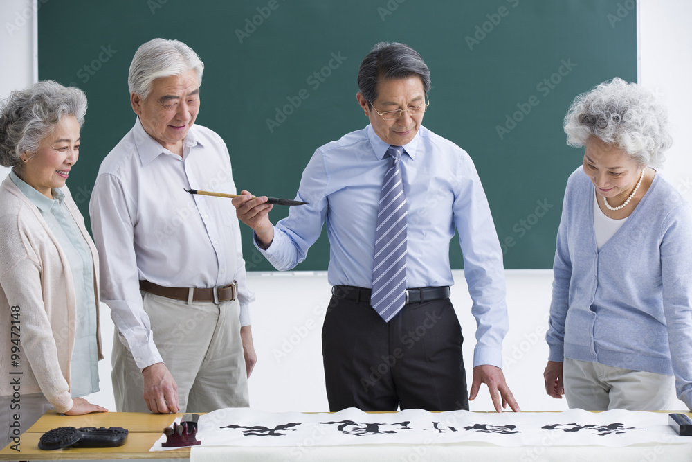 Senior adults having calligraphy class at school