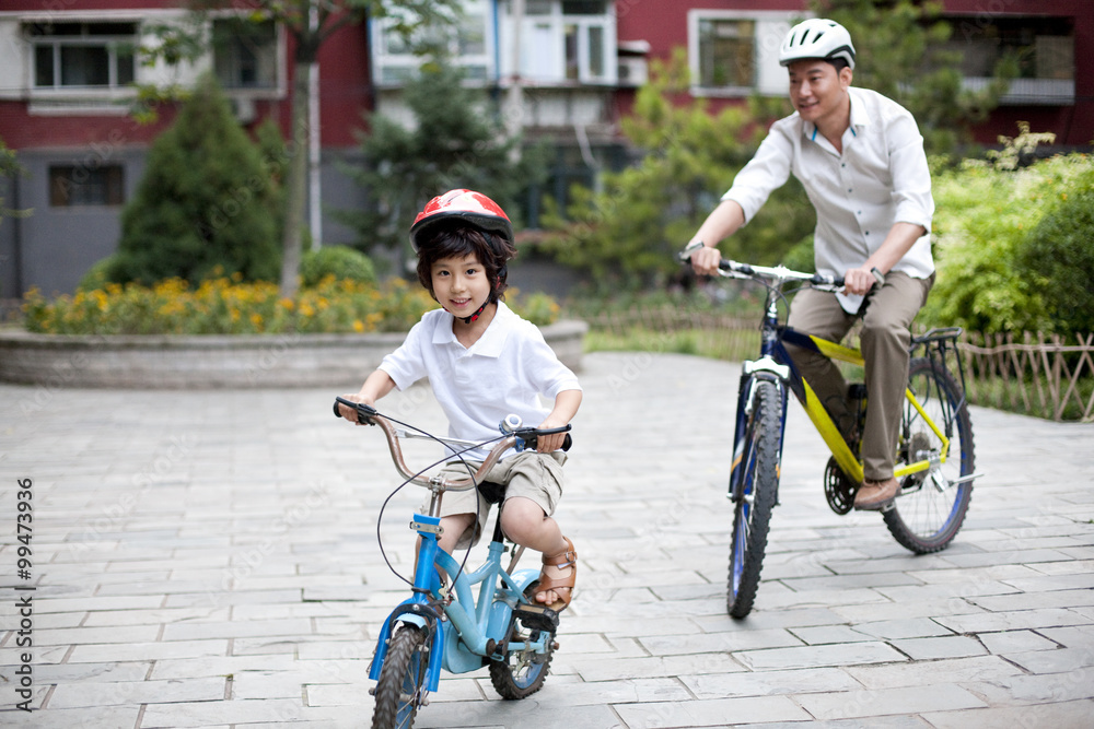 Father and son riding bicycles in a common community