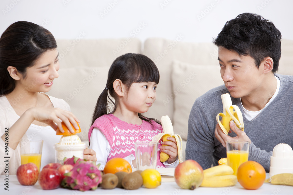 Happy family eating fruits at home