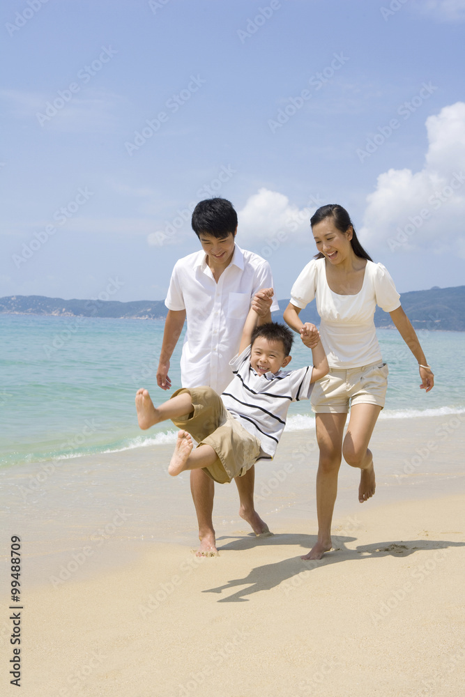 在海滩上玩耍的年轻家庭