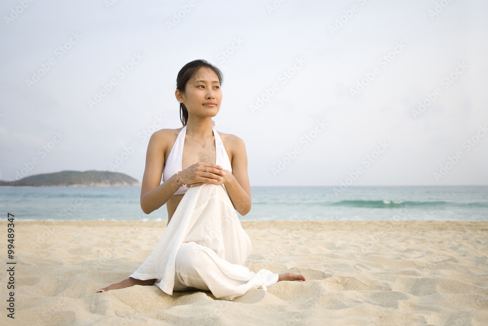 在海滩上做瑜伽的年轻女人