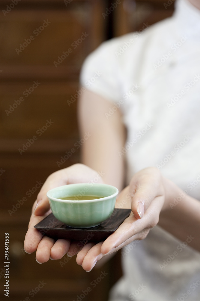 年轻女子端中国茶