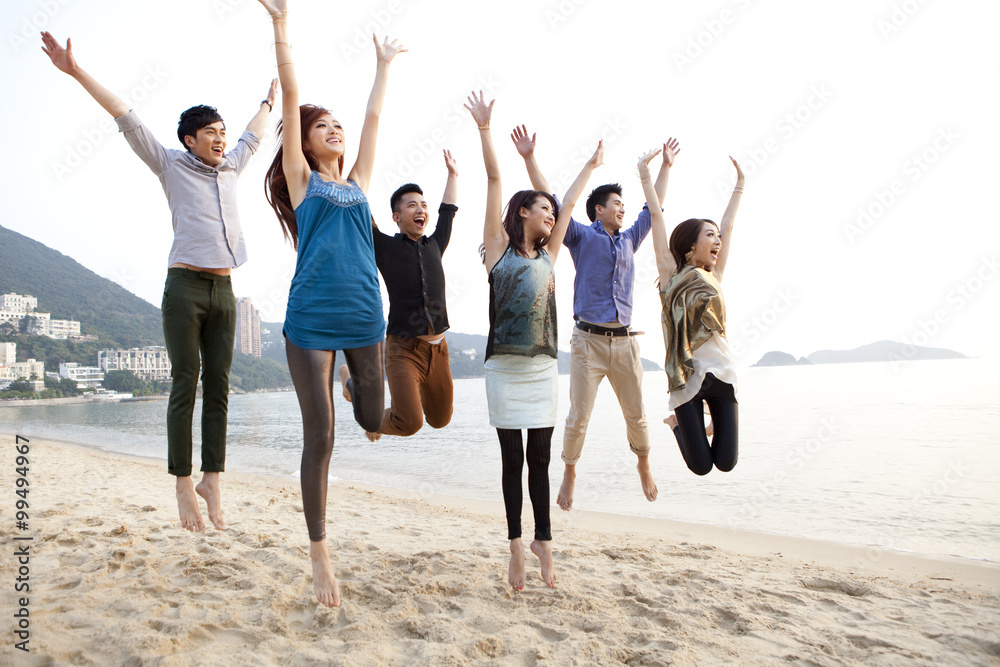 香港浅水湾海滩上兴奋的年轻人在空中跳跃