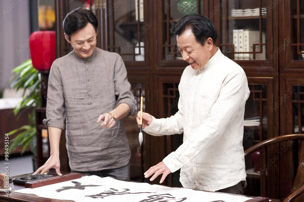 Male friends practicing calligraphy in the study