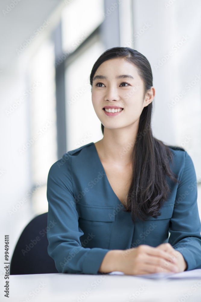 Young businesswoman thinking in office