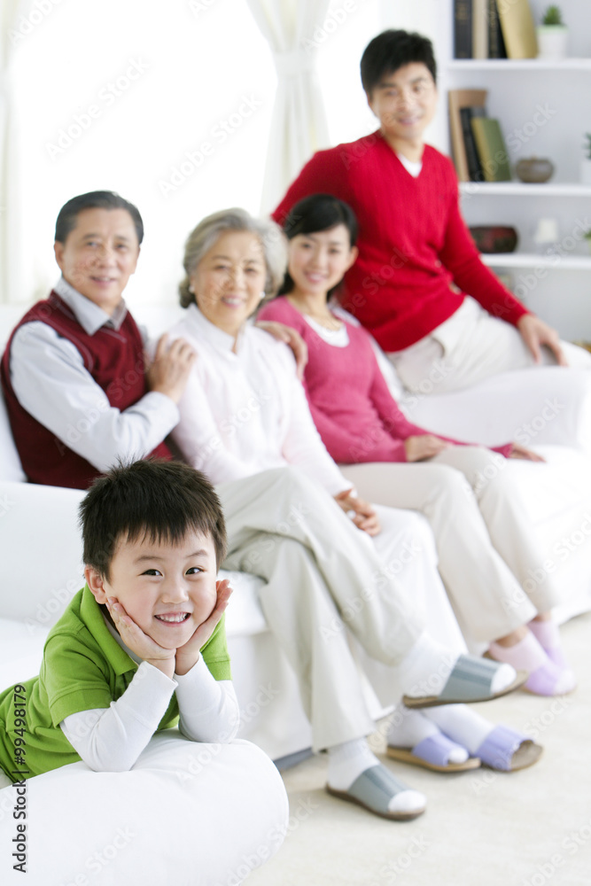 客厅里的中国小男孩，背景是父母和祖父母